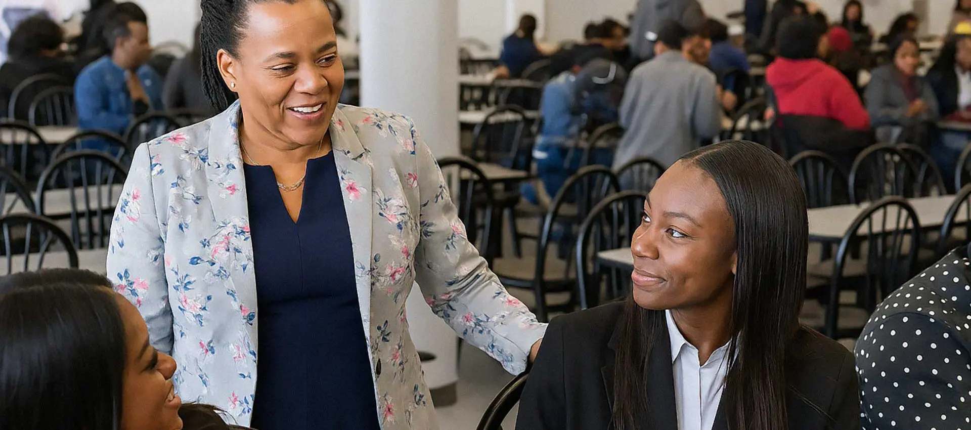 Manager talking to students at table