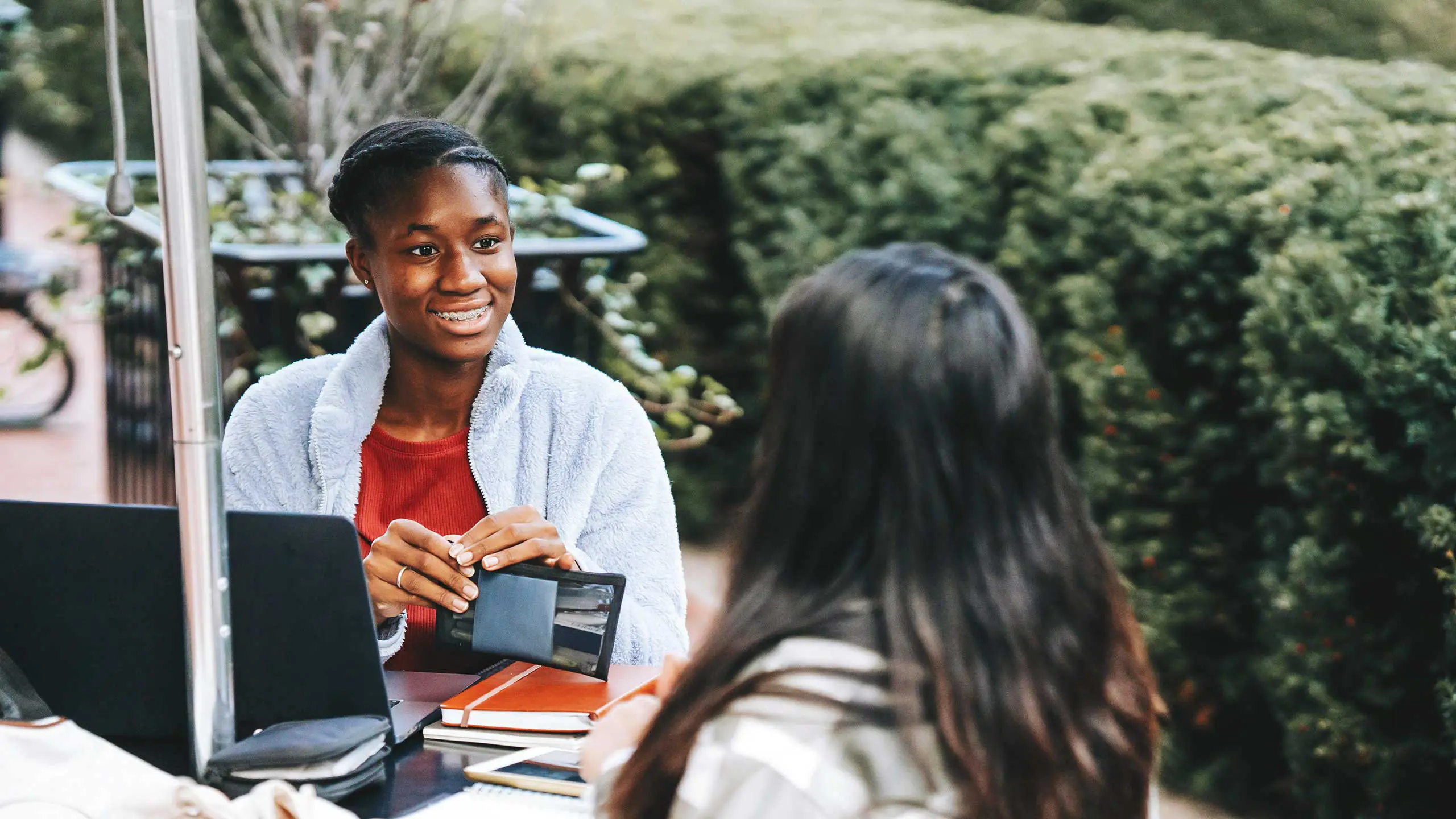 Two students sitting outside talking